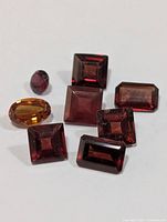 All eight loose garnet stones displayed on white background