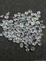 Loose faceted gemstones spread out on dark background