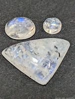 Three moonstone cabochons lined on dark background