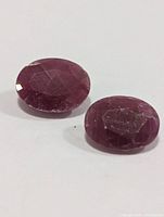 Two loose oval rubies on white background