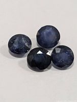 Close-up of four round blue sapphires
