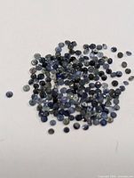 Pile of loose round blue sapphires on white background