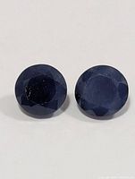 Close-up of two round faceted sapphires showing colour and cut