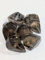 Six smoky quartz gemstones close-up showing color and facet quality