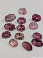 Group of loose faceted pink tourmaline stones on white background