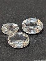Three oval white topaz gemstones on black background