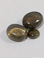 Three cat’s eye cabochon gemstones on white background
