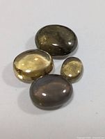 Top view of four cat's eye cabochons on white background