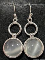 Frontal view of both earrings showing cabochon stones and silver setting
