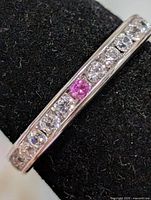 Front view of silver eternity ring showing clear and pink cubic zirconia stones