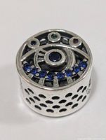 Top view of sterling silver charm bead showing spiral design and coloured stones