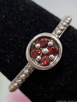 Close-up of bezel showing garnet stones and bead centre