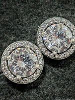 front view of both halo CZ earrings on dark background