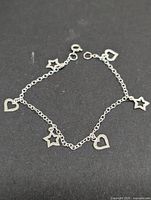 Full view of silver bracelet with heart and star charms