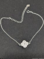 Full view of silver chain bracelet with CZ clover charm and extender