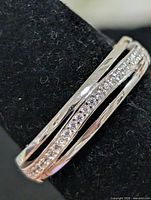 Close view of split-band ring showing row of cubic zirconia