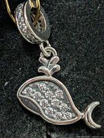 Front view of sterling silver whale pendant with CZ