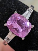 Front view of ring showing pink cushion-cut stone and side baguettes