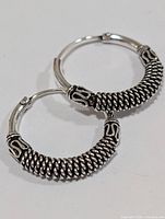 Front view of both silver hoop earrings with twisted wire detail