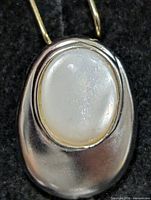 Front view showing mother of pearl cabochon and silver frame