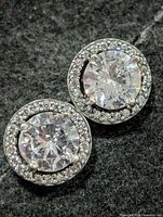Front view of both earrings showing central CZ and halo stones