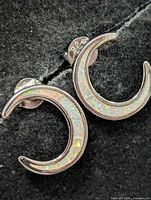 Both earrings front showing opal inlay and crescent shape