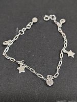Full view of silver paperclip chain bracelet with star and CZ charms