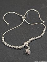 Full view of silver adjustable bead bracelet with star charm