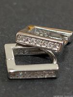 Two square sterling silver hoop earrings showing CZ stones and 925 stamp