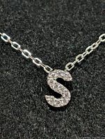 Close-up of cubic zirconia "S" pendant on chain