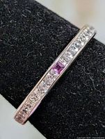 Side view of ring showing channel-set CZ stones and purple accent