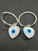 Front view of both hoop earrings with heart mother-of-pearl evil eye charms