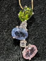 Front view showing three oval coloured stones and clear CZ accents
