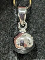 front view of polished silver sphere pendant