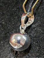 Front view of polished silver sphere pendant on bail