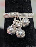 Front view of silver band ring with three ball charms
