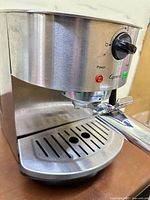 Front angled view showing stainless body, portafilter and drip tray