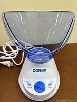Steamer base with attached facial mask cone and power cord