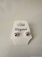 Front view of Elégance card with silver ball stud earrings attached
