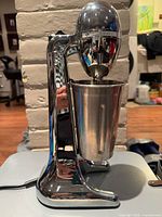 Front view of chrome Hamilton Beach drink mixer with stainless steel cup attached