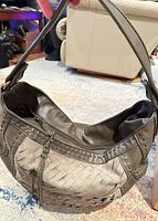 Front view showing overall shape, color, woven suede overlay and chain tassel
