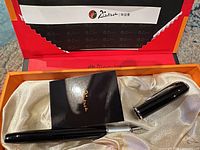 Fountain pen, cap, booklet inside open Picasso box