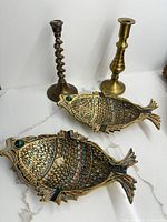 Two enamelled brass fish trays and two brass candlesticks group shot