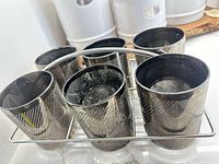 Front view of six silver chevron tumblers seated in chrome rack