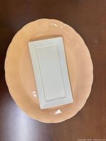 Peach oval platter under white rectangular serving dish