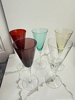 Five colored cordial glasses grouped on surface