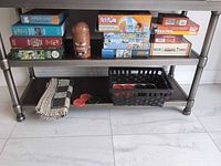 Shelf with boxed puzzles, board games, barrel accessory, checkers set and basket