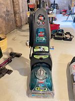 Full view of Bissell ProHeat Turbo 2X upright carpet cleaner with hose and accessories attached