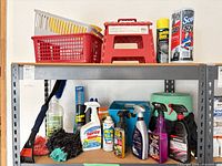 Two-shelf unit holding cleaners, tools, stool, baskets