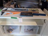 Overview of drafting tools, compass set, triangle, T-square on shelf